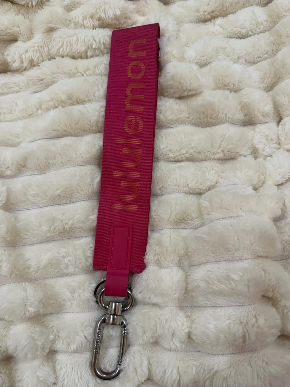 lululemon pink logo wristlet strap with orange lettering